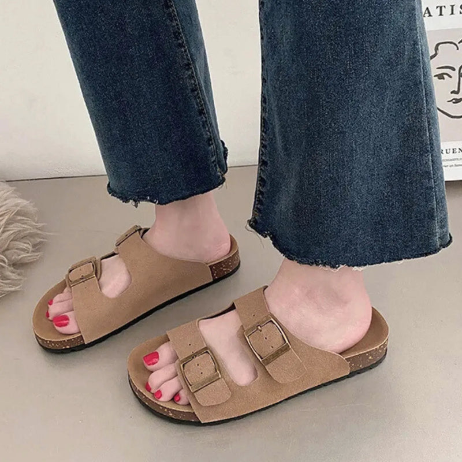 A foto destaca o design casual da sandália com duas fivelas ajustáveis, sola de cortiça e suporte de arco, ideal para conforto diário.