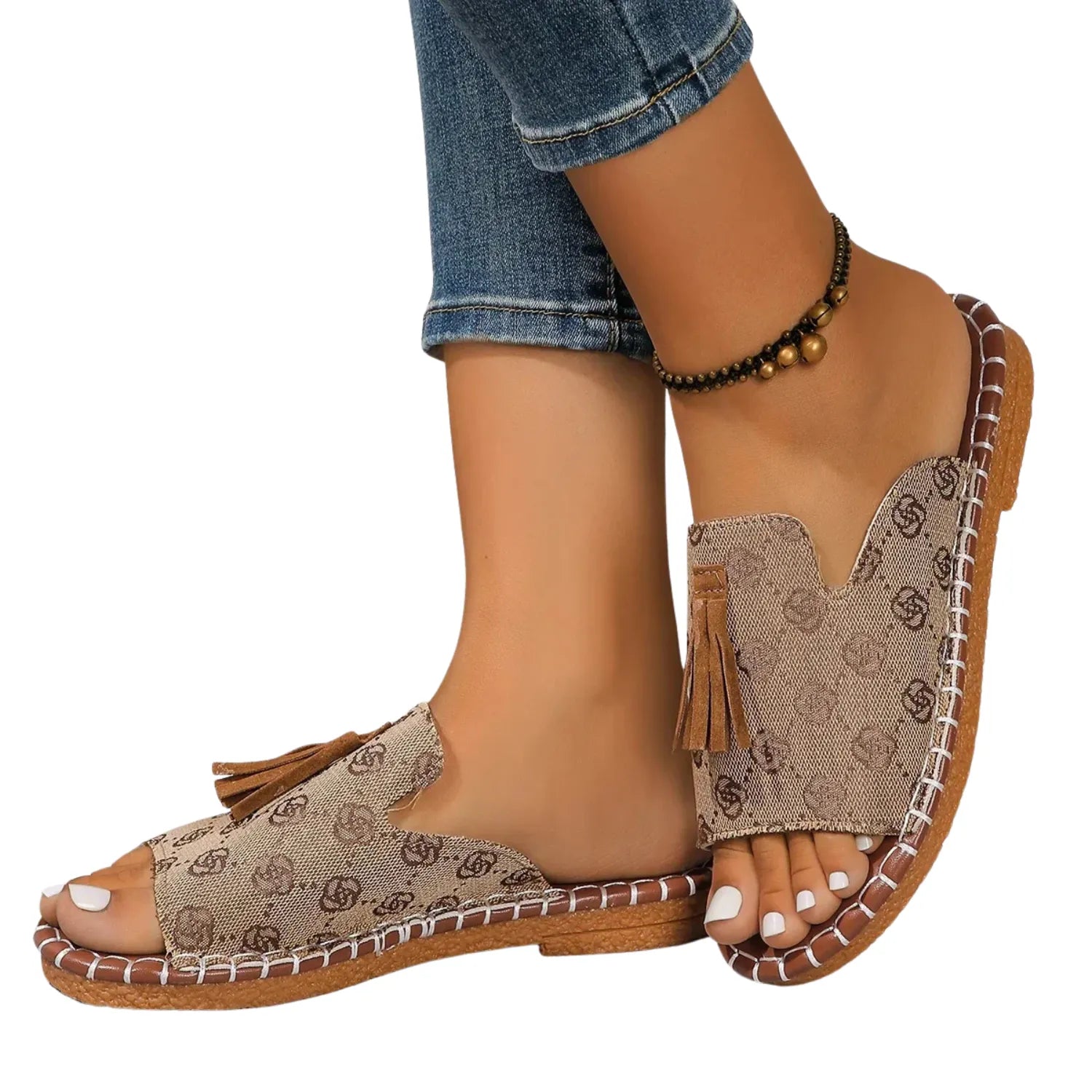 Chinelo slide feminino sendo usado por uma pessoa. O calçado possui uma tira larga com detalhe de borla e uma sola com costura contrastante, ideal para estilo e conforto.