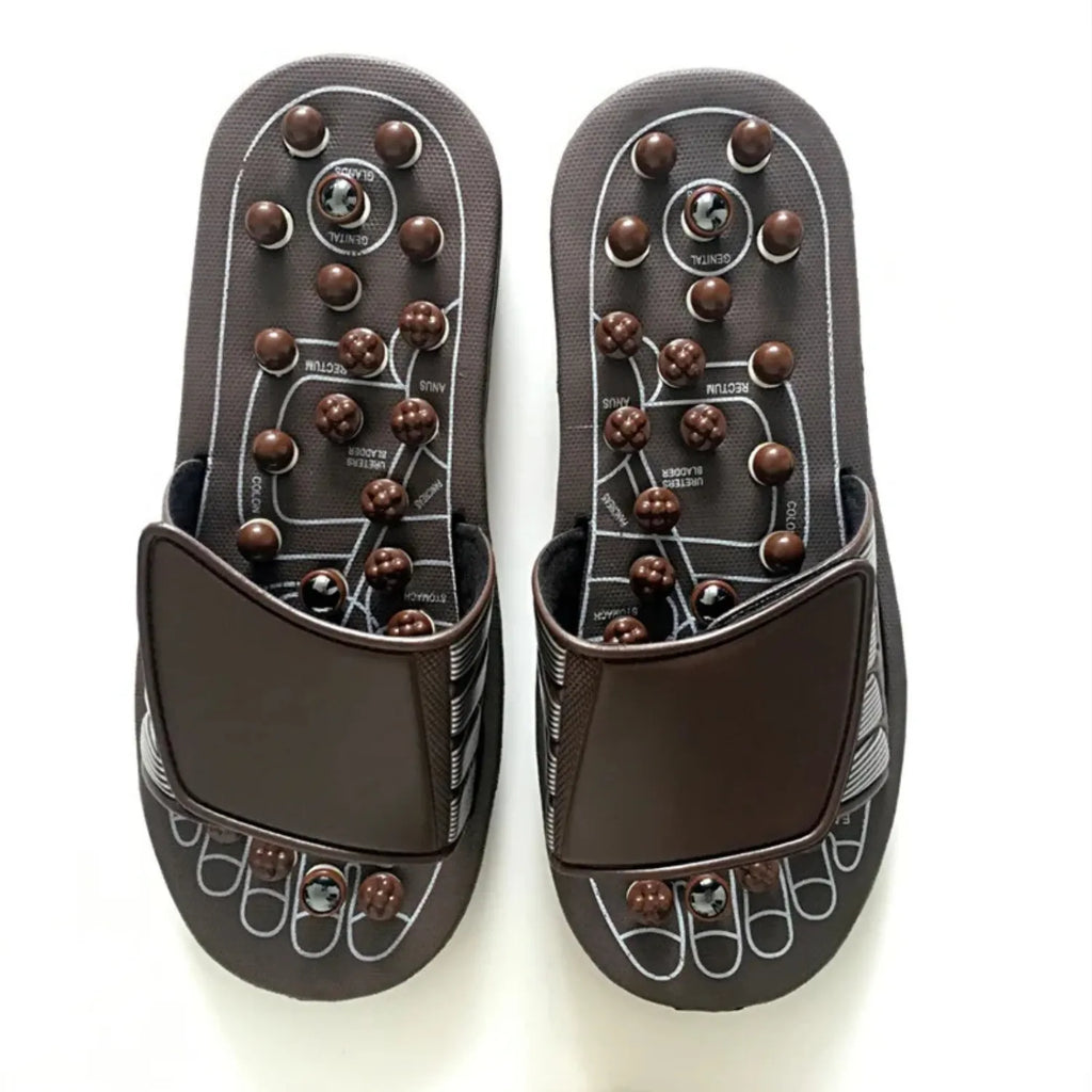 Um par de chinelos de massagem de acupressão, com nódulos de plástico na sola. Possui tira superior ajustável e um diagrama de pontos de reflexologia para terapia e alívio dos pés.