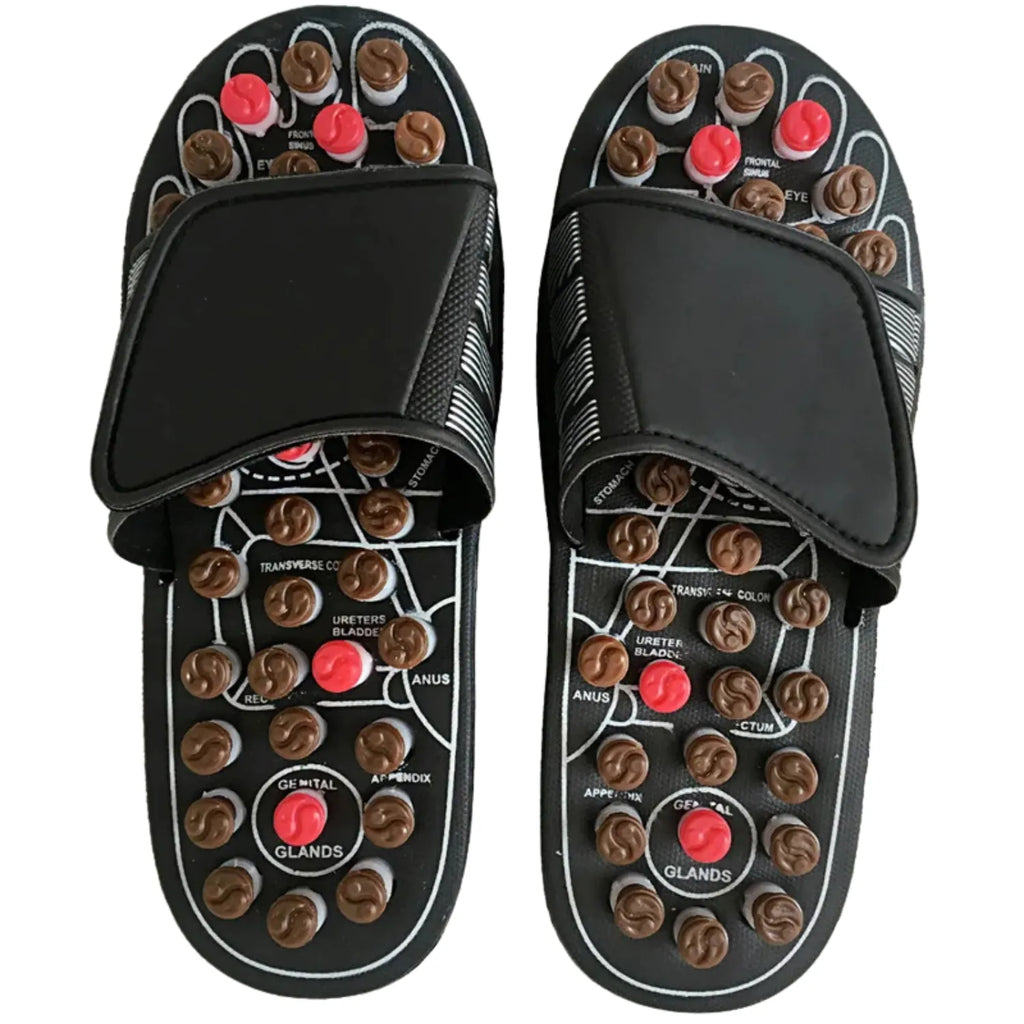 Um par de chinelos de massagem de acupressão, com nódulos de plástico coloridos na sola. O calçado possui uma tira superior ajustável e um diagrama de pontos de reflexologia para terapia e alívio dos pés.