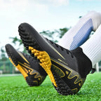 Par de chuteiras de futebol society unissex. A imagem exibe a sola com travas.