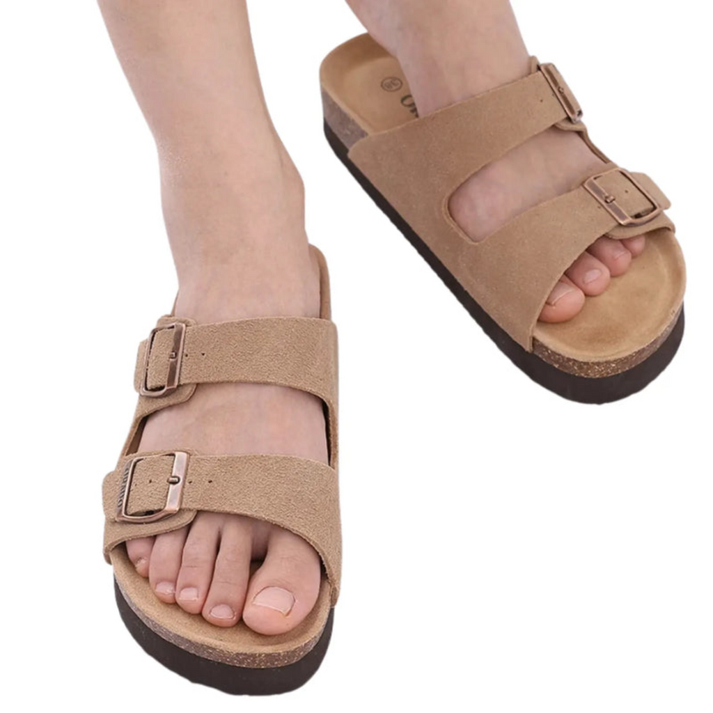 Um par de sandálias de cortiça marrom com duas tiras largas, fivelas de metal ajustáveis e sola com suporte de arco para bastante conforto.