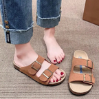 Um par de sandálias de cortiça com duas tiras largas, fivelas de metal ajustáveis e sola com suporte de arco para máximo conforto, na cor marrom.