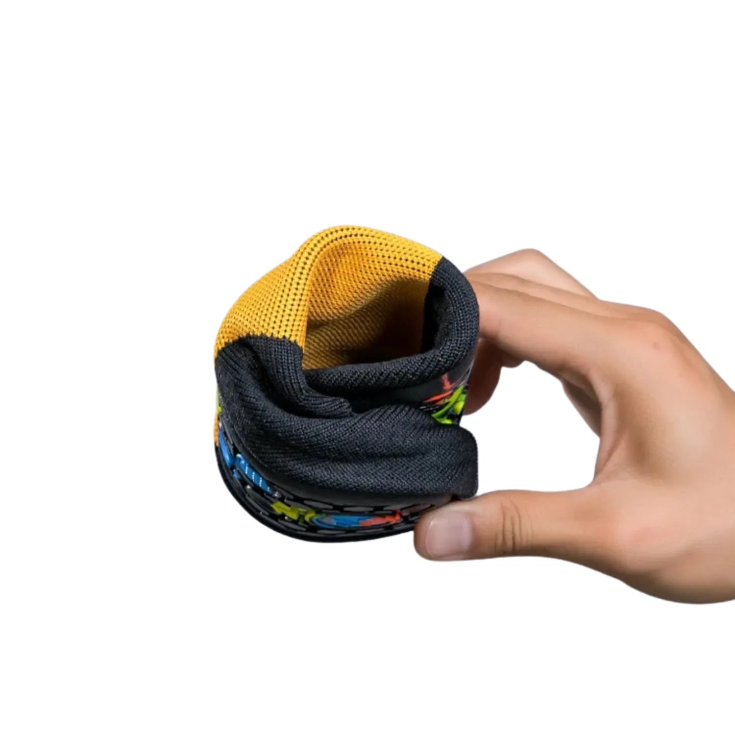 Uma mão segurando e dobrando um tênis de yoga, demonstrando a flexibilidade e a leveza do calçado.