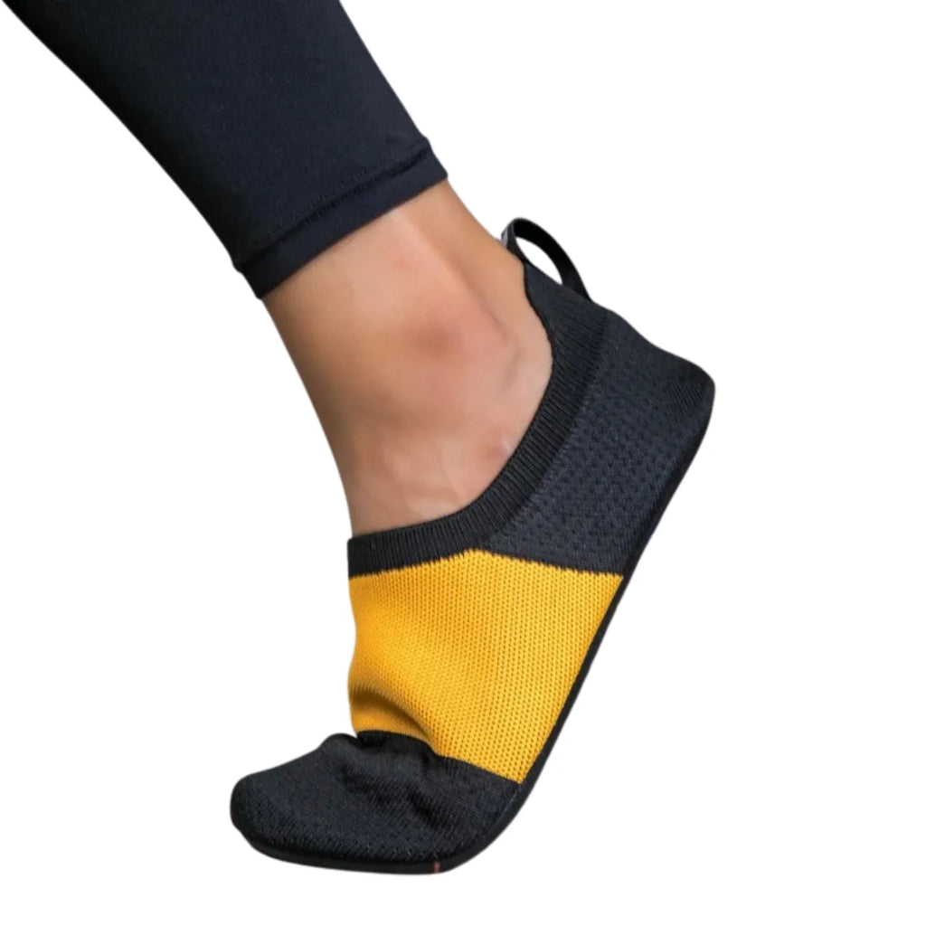 Foto de tênis de yoga unissex, com design slip-on de tecido flexível tipo meia e sola fina, ideal para exercícios de flexibilidade e proteção.